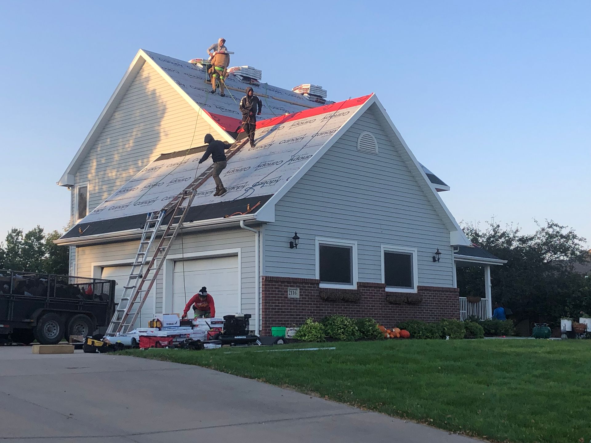 A group of people are working on the roof of a house.