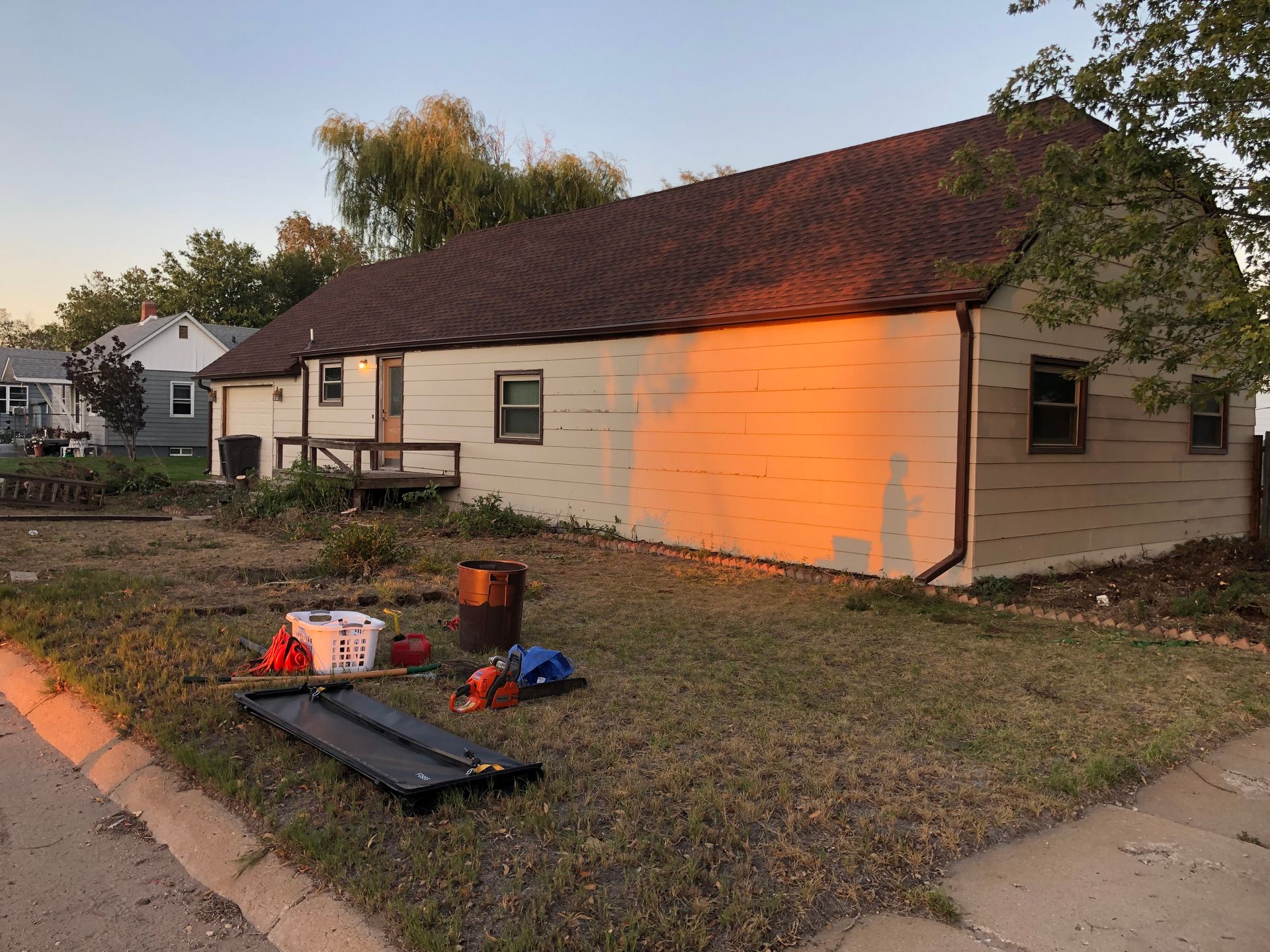 A house with a red roof is sitting on the side of the road.