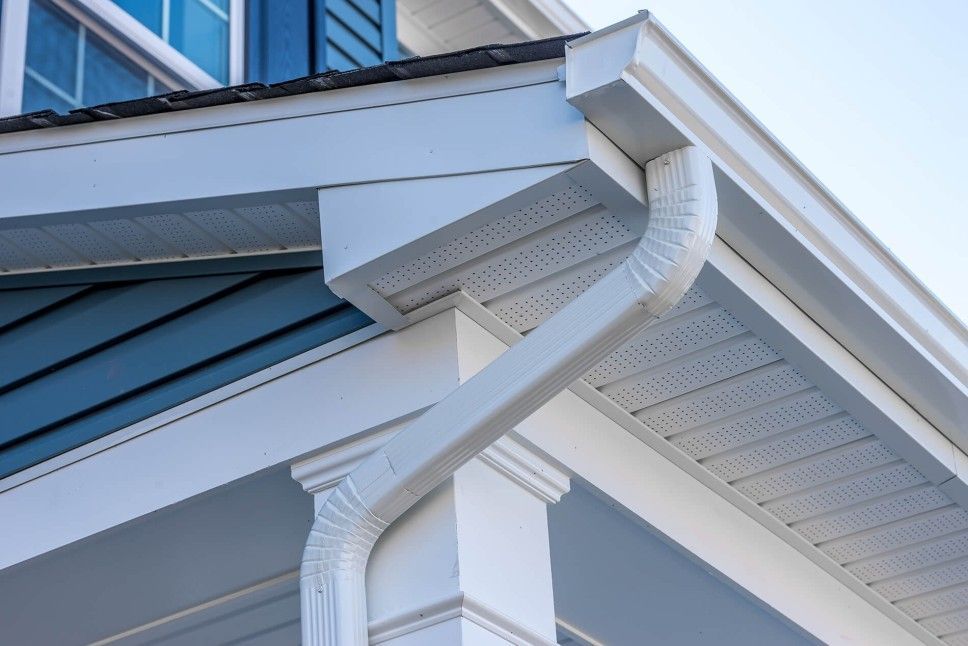 A close up of a gutter on the side of a house.