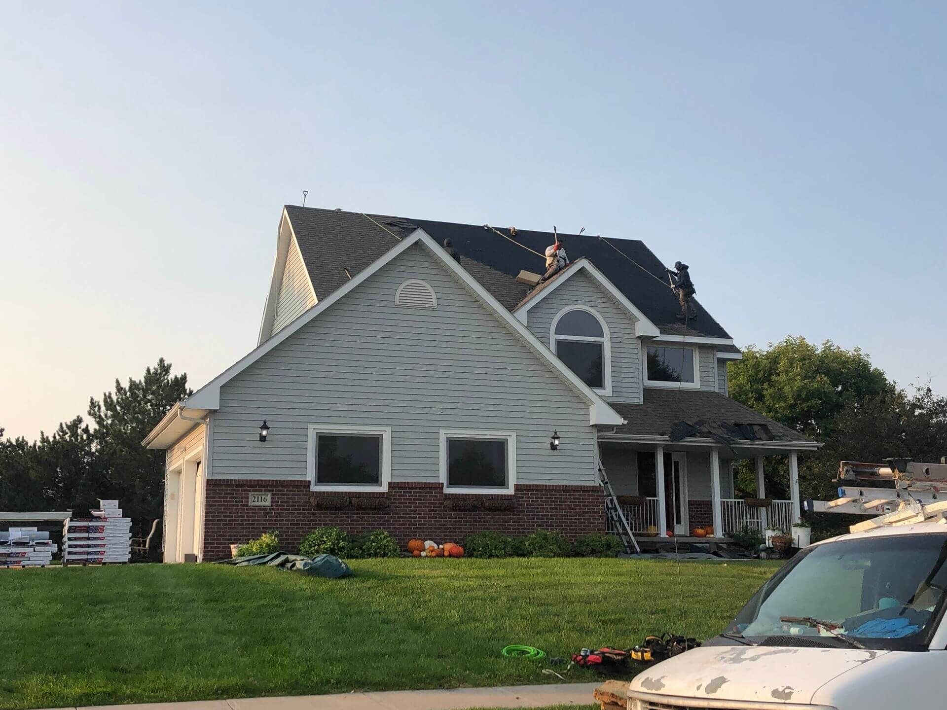 An aerial view of a house with a gray roof in a residential area.