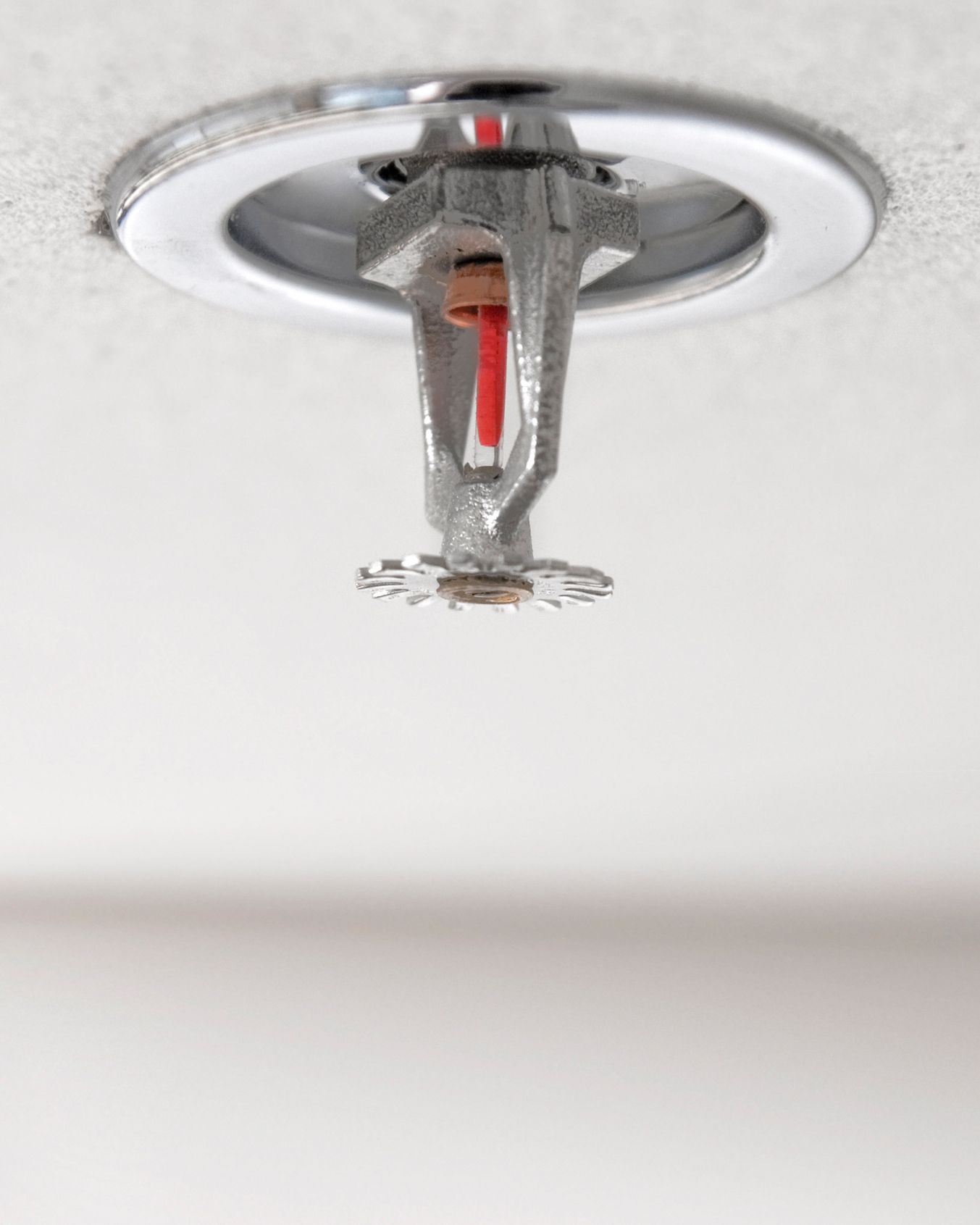 A fire sprinkler is hanging from the ceiling in a room.