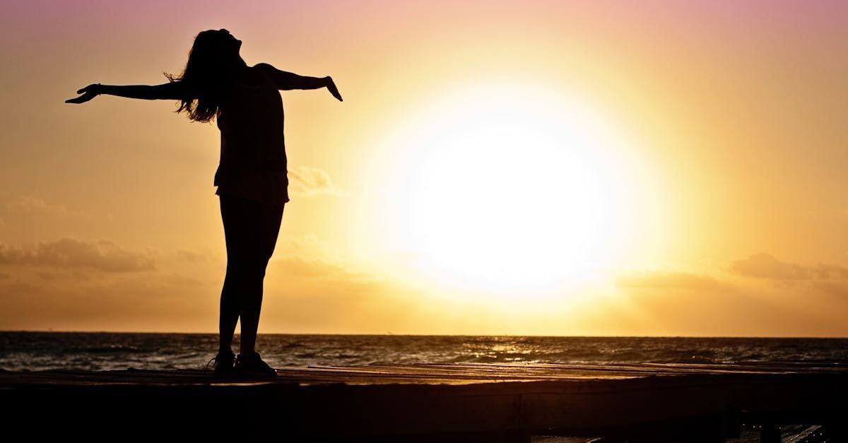 Women standing at horizon with arms stretched enjoying Mota Mystic.