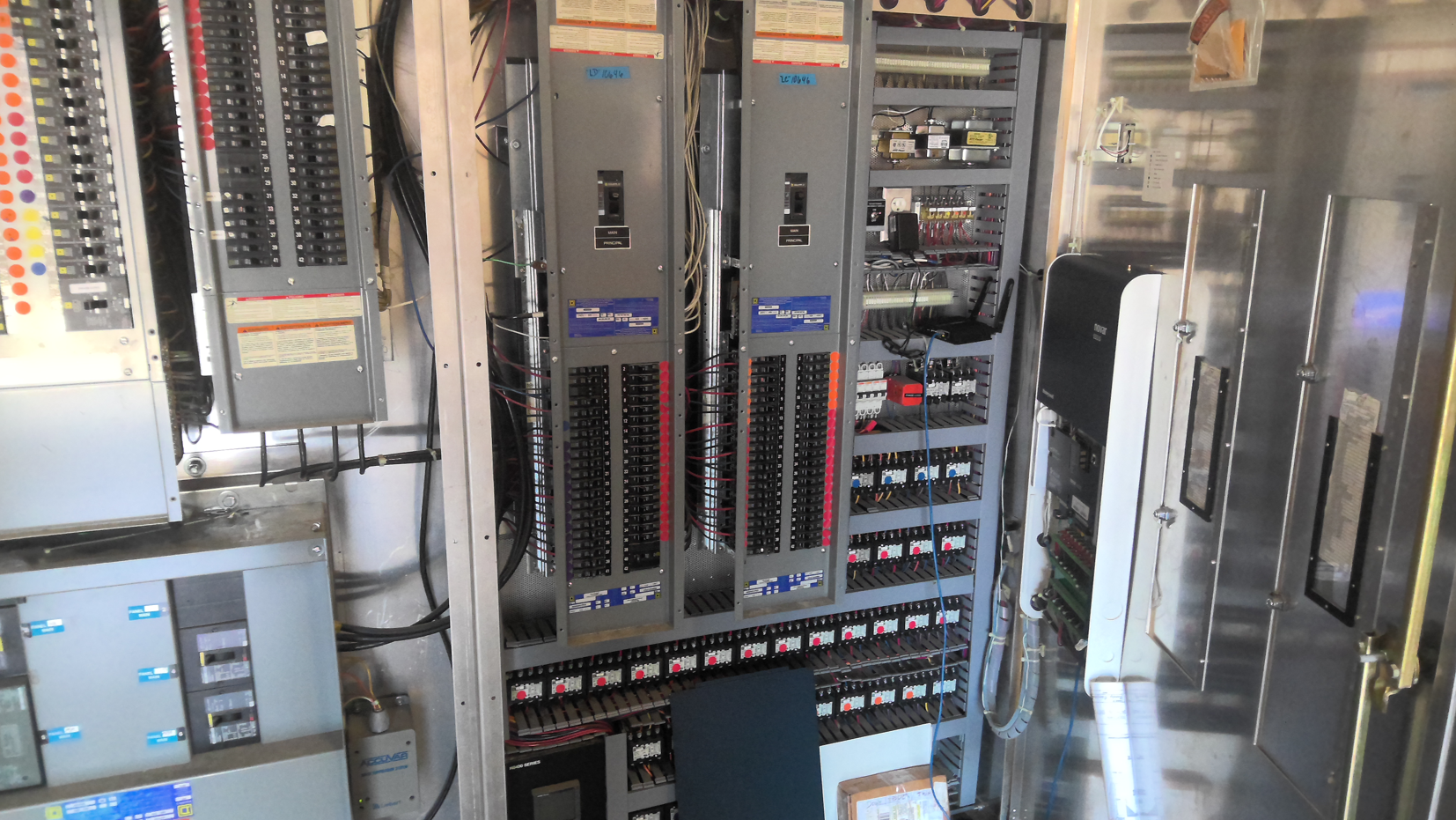 Electrical control panel with wiring, breakers, and circuit modules inside a metal cabinet.