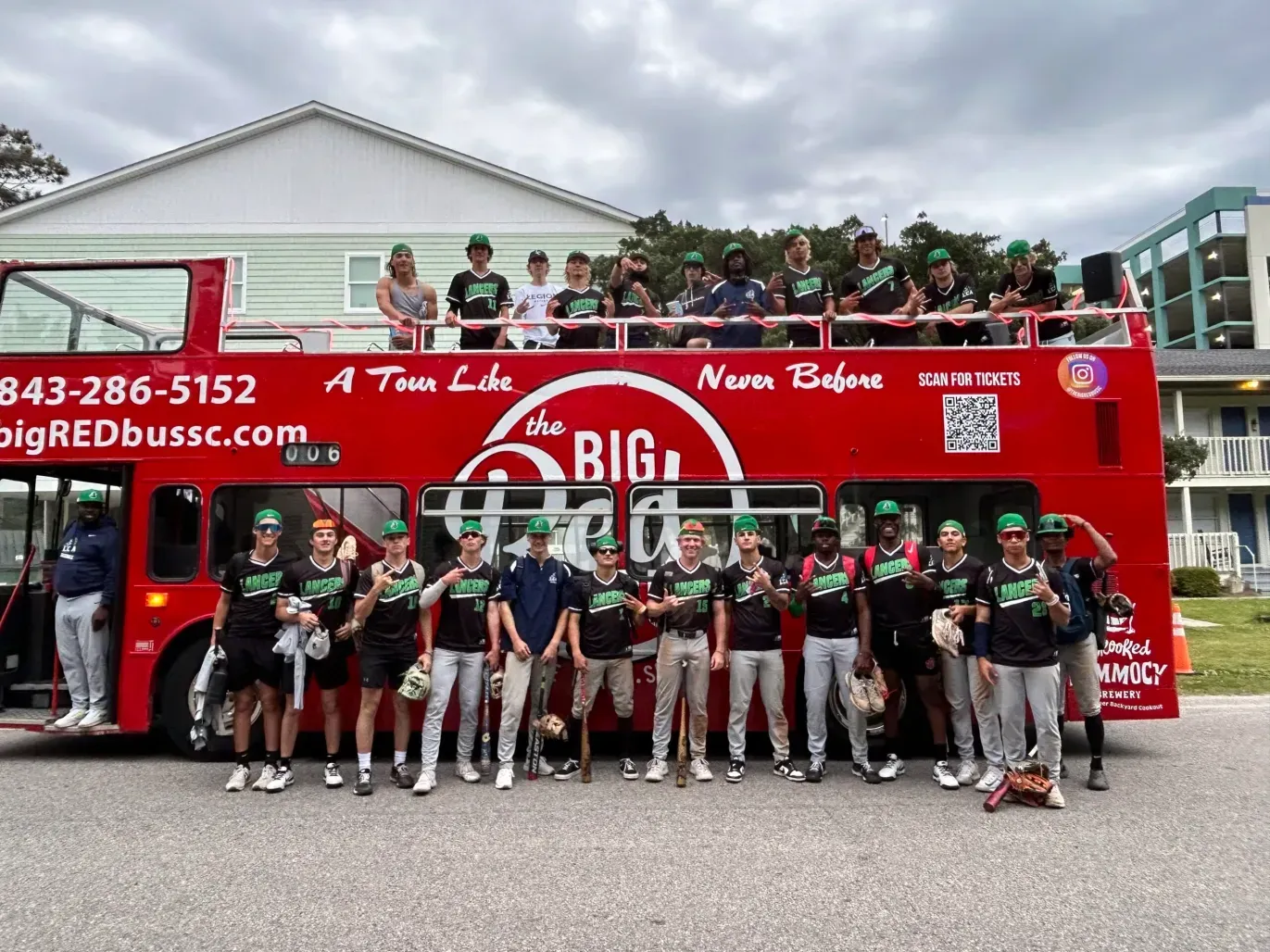 A group of people are standing in front of a red double decker bus.