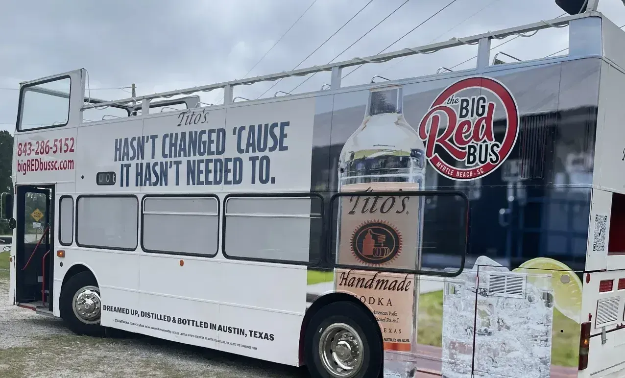 A double decker bus is parked in a parking lot