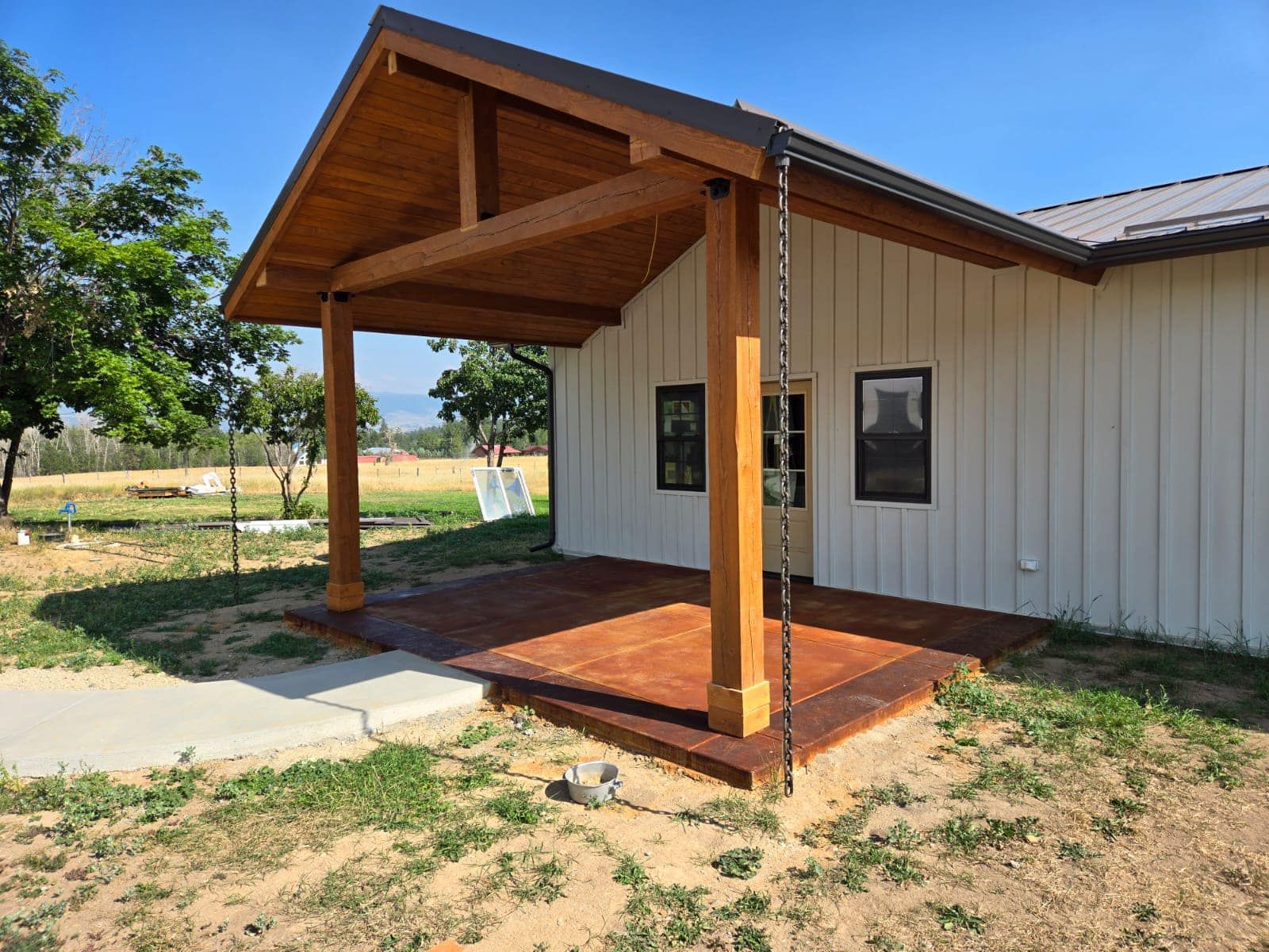 A white house with a wooden porch and a chain link fence.