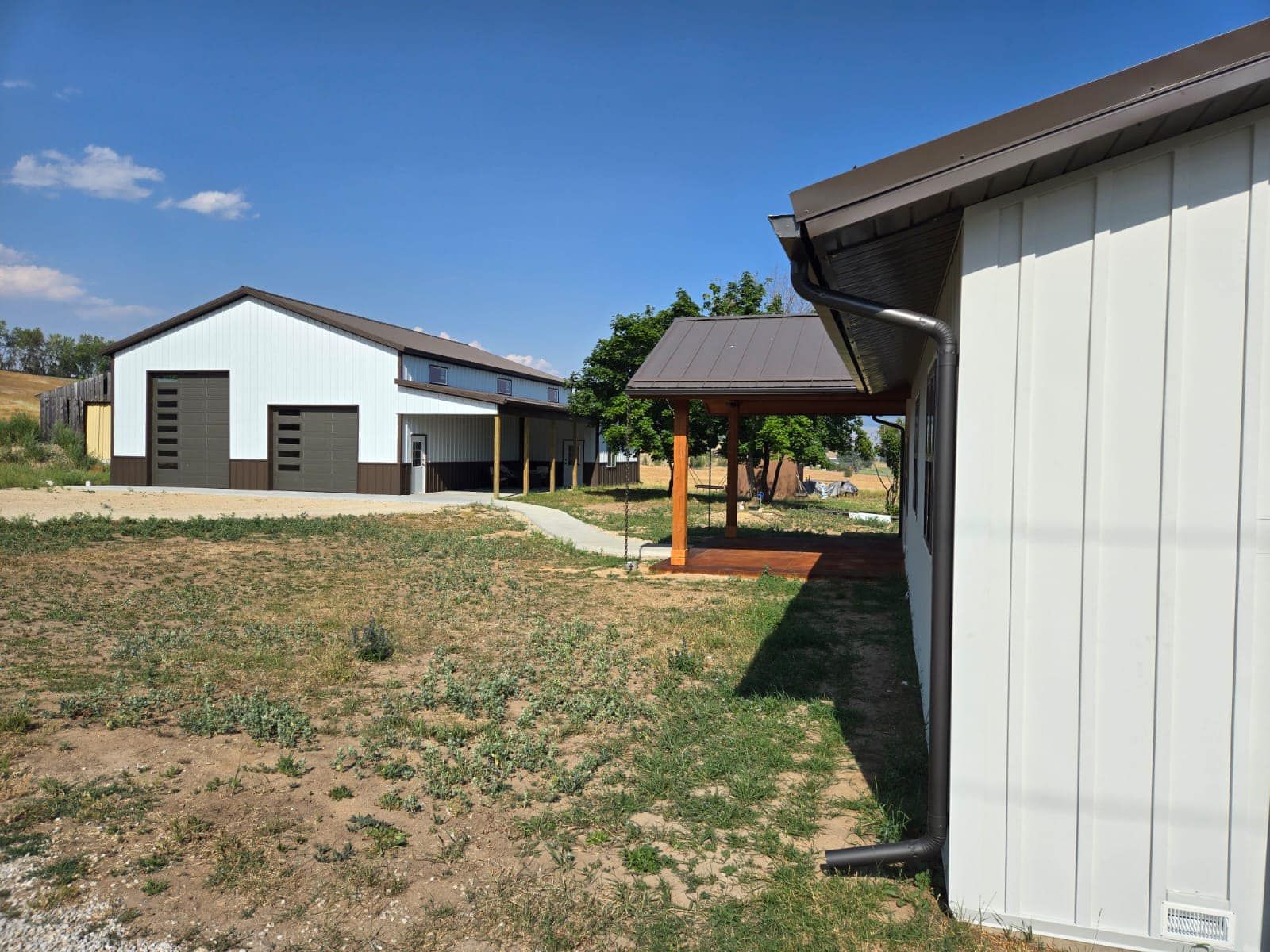 A white building with a brown roof is next to a white building with a brown roof.