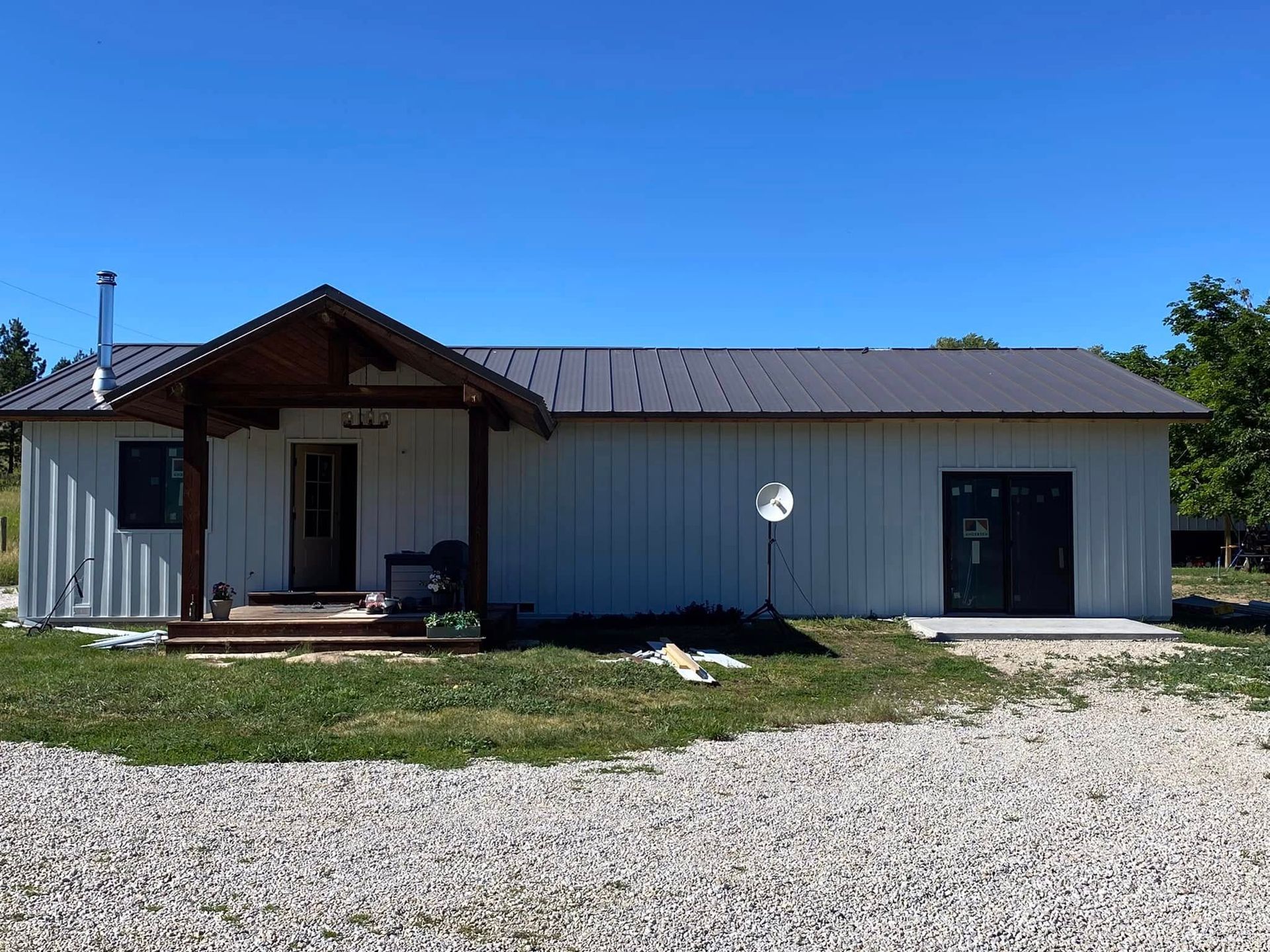 A white house with a metal roof and a porch