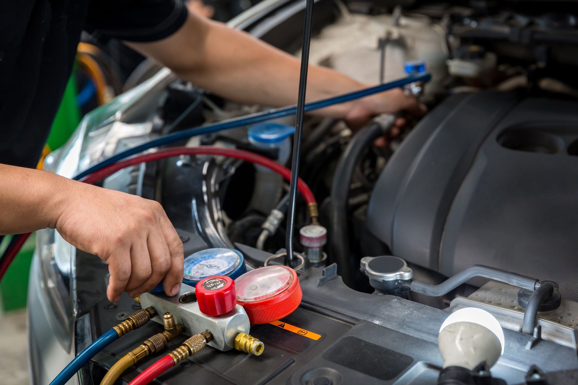A man is working on the engine of a car.