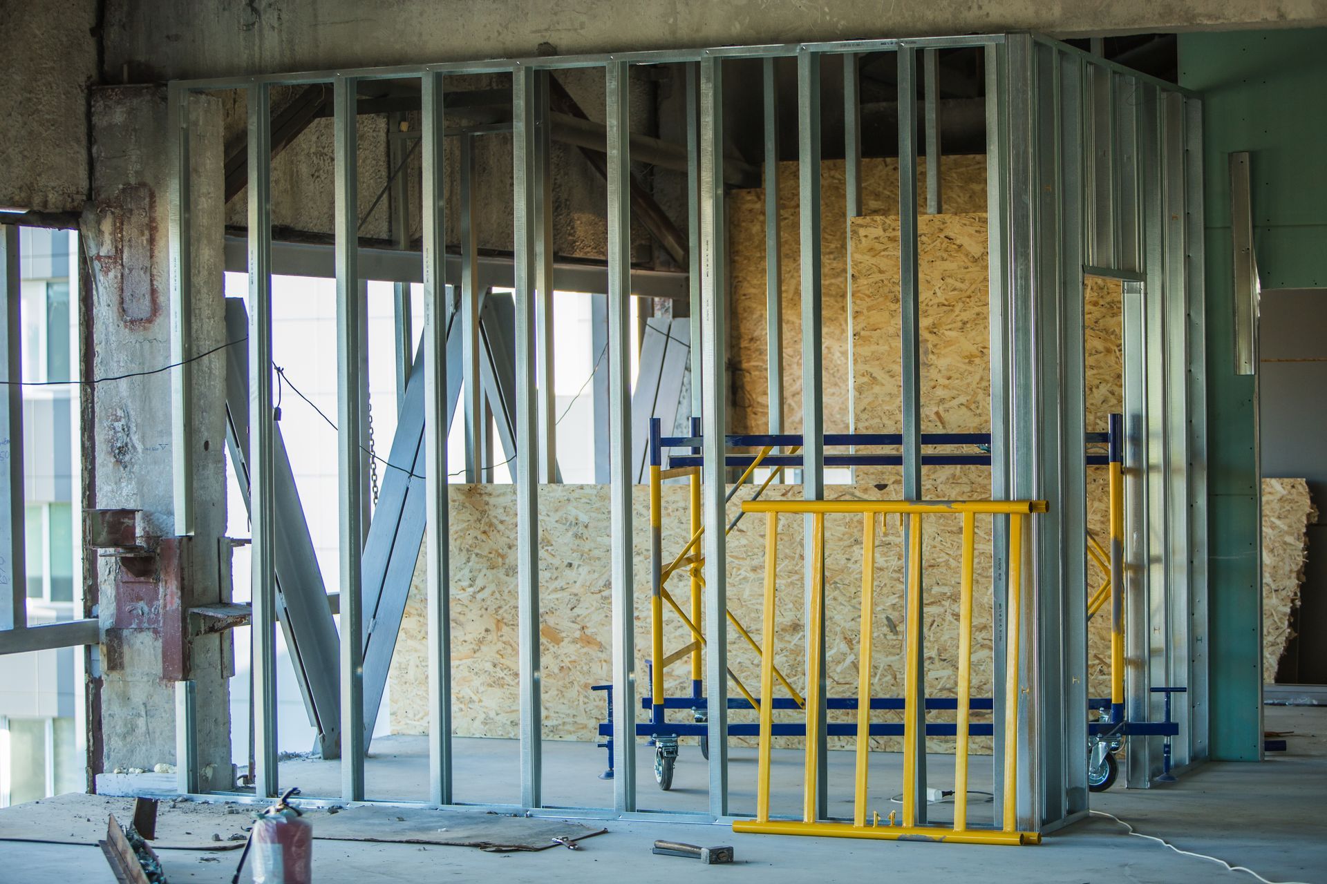 Un bâtiment en construction avec des charpentes métalliques et des échafaudages.