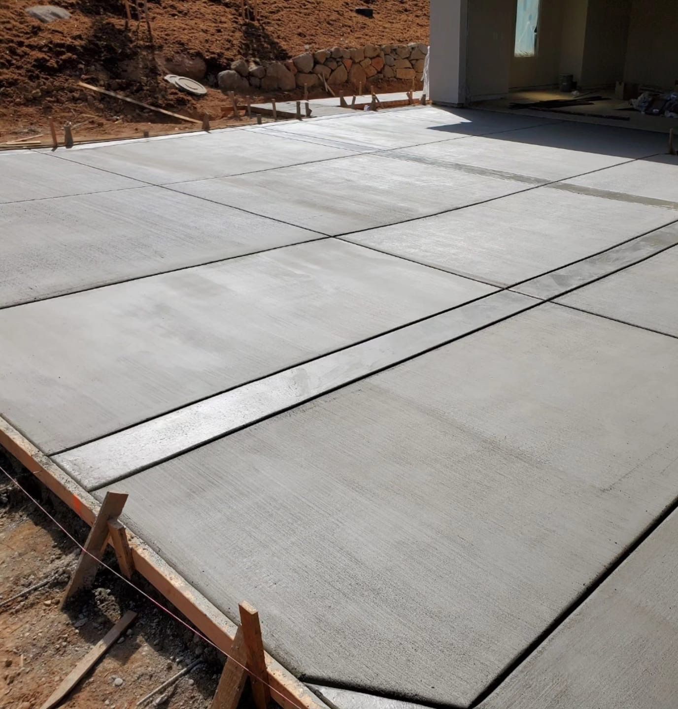 New concrete driveway is being built in front of a house.