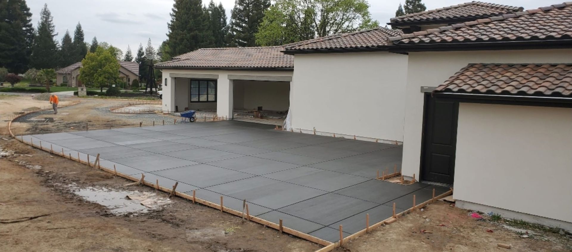 A concrete driveway is being built in front of a house