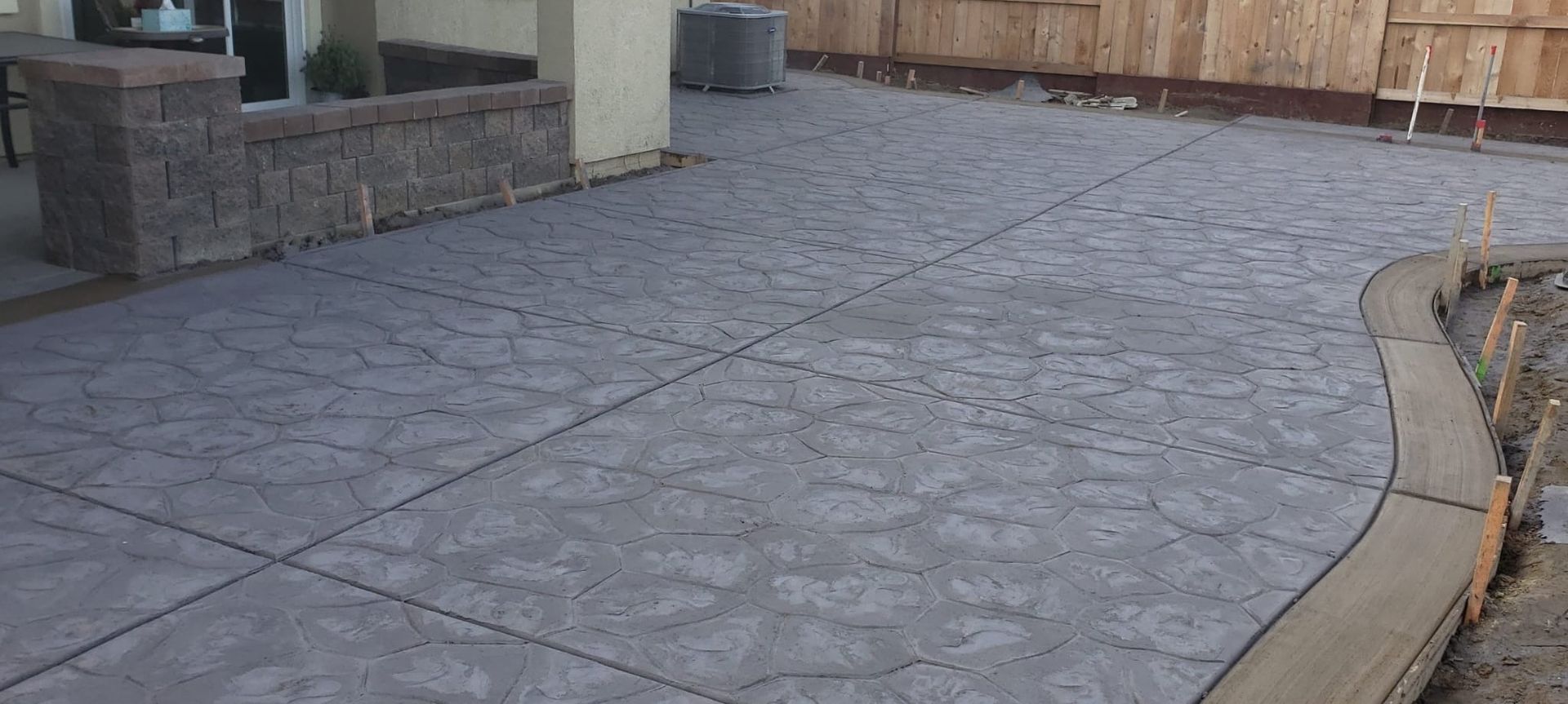 A stamped concrete walkway is being built in front of a house.