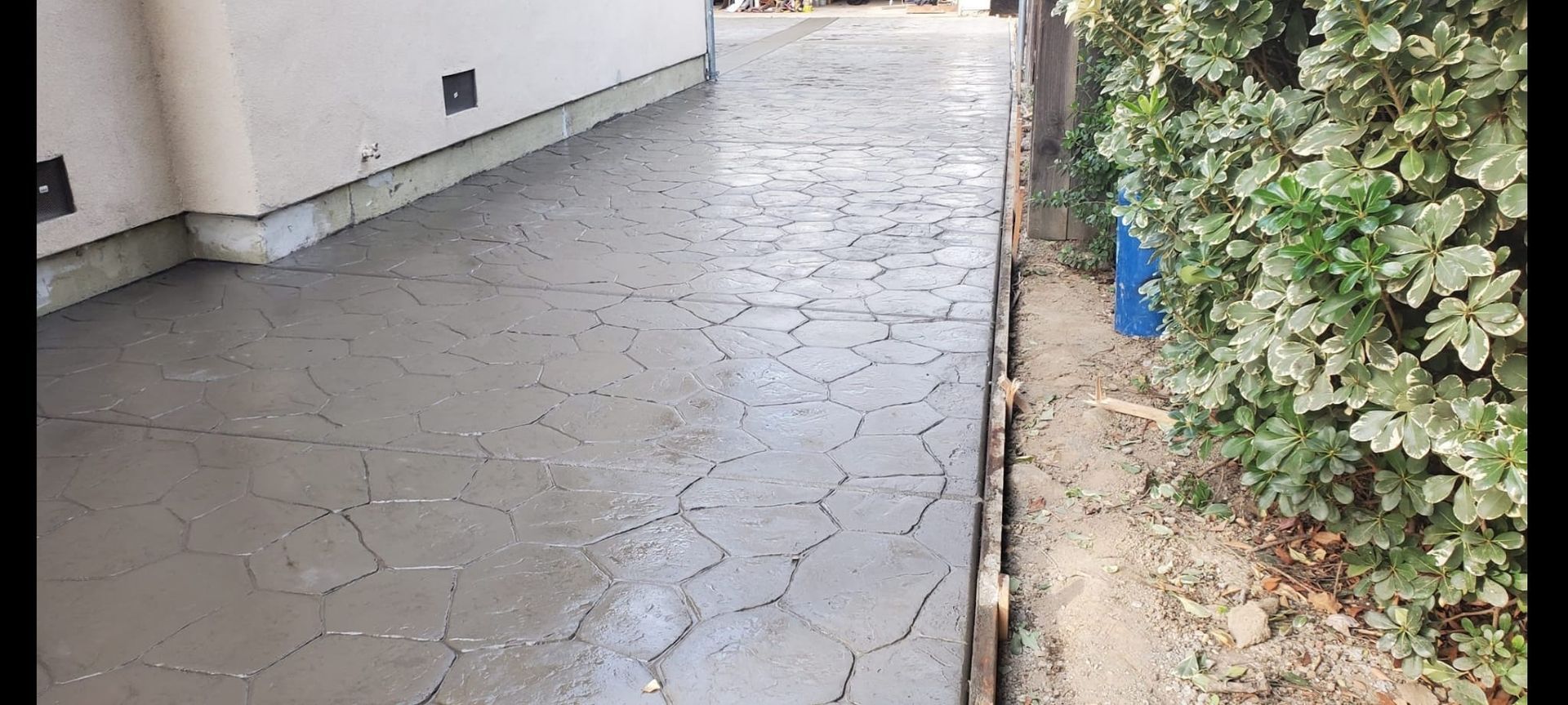 A concrete walkway is being built in front of a house.