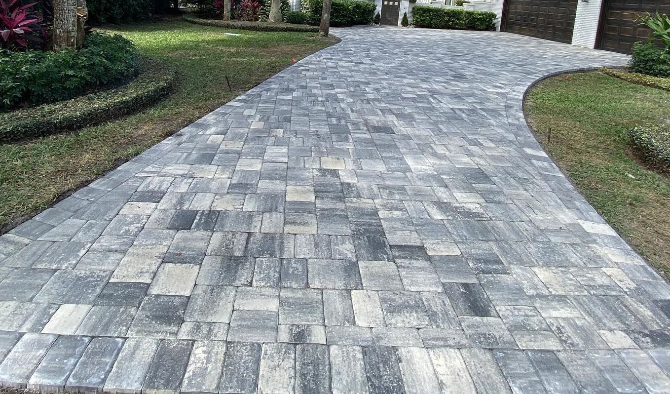 A brick pavement leading to a house in a residential area.