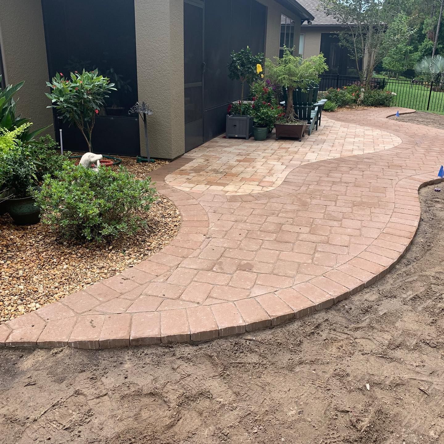 A brick pavement is being built in front of a house