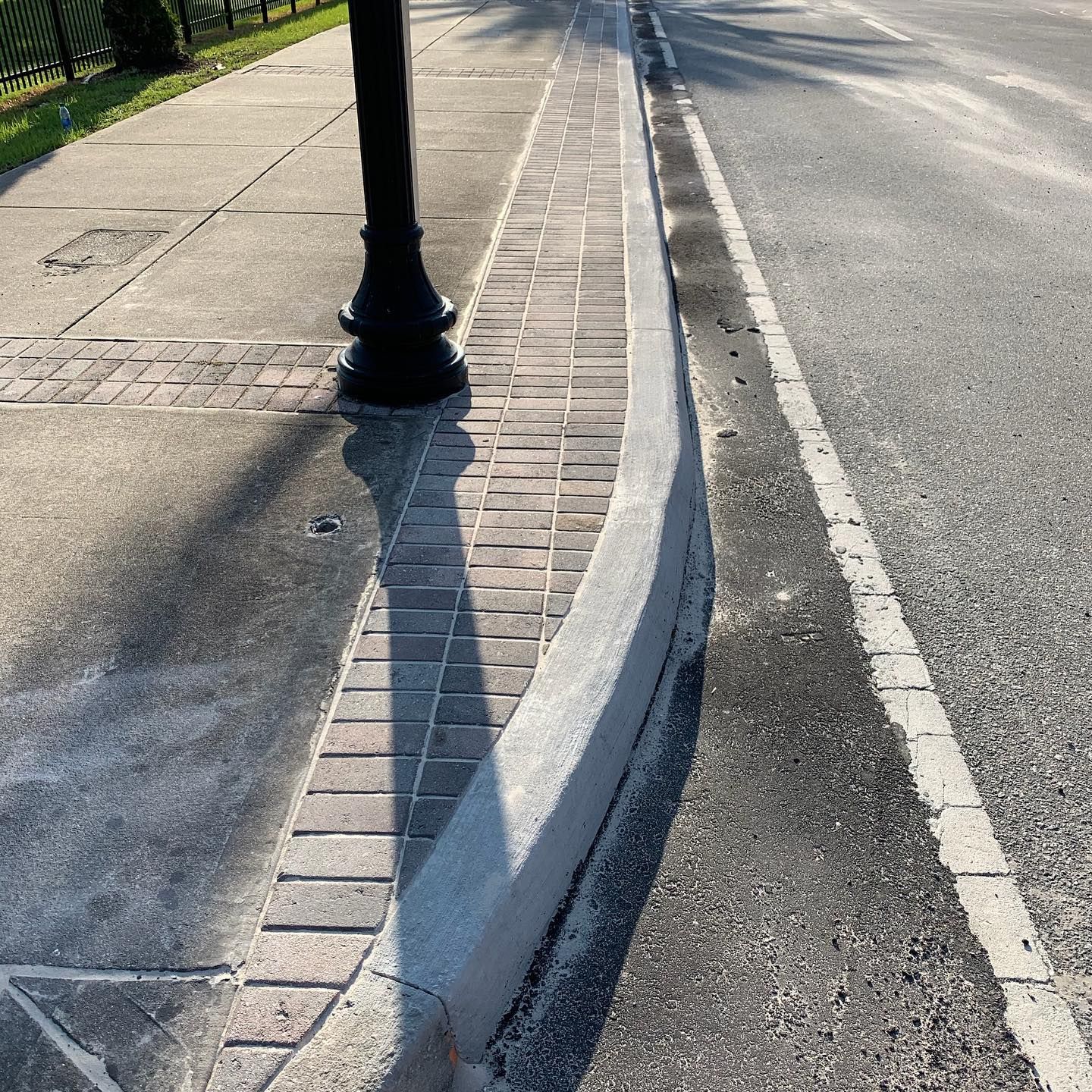 A street with a curb and a brick sidewalk