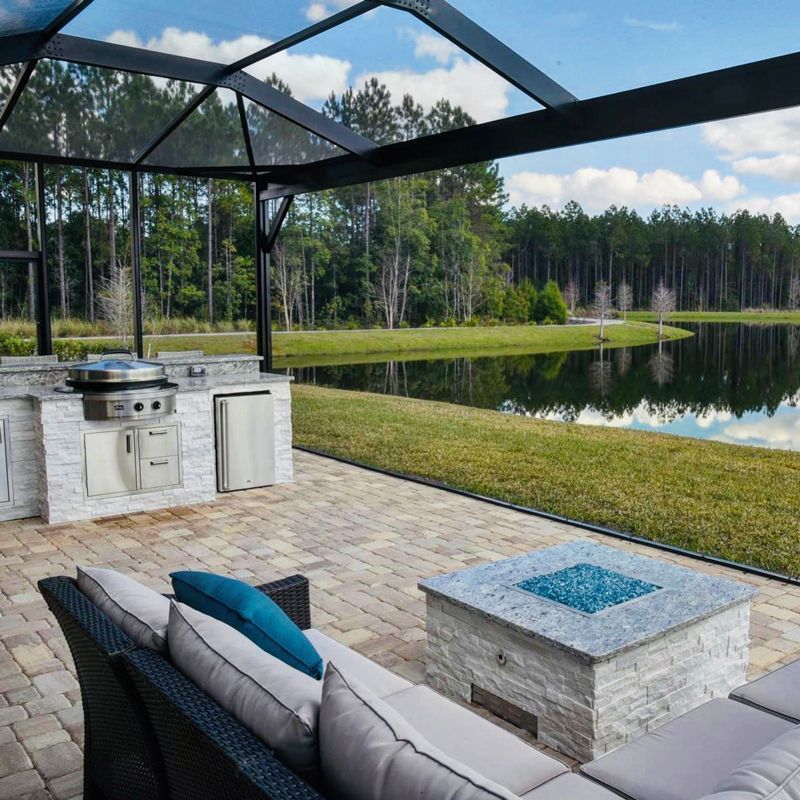 A patio with a fire pit and a view of a lake