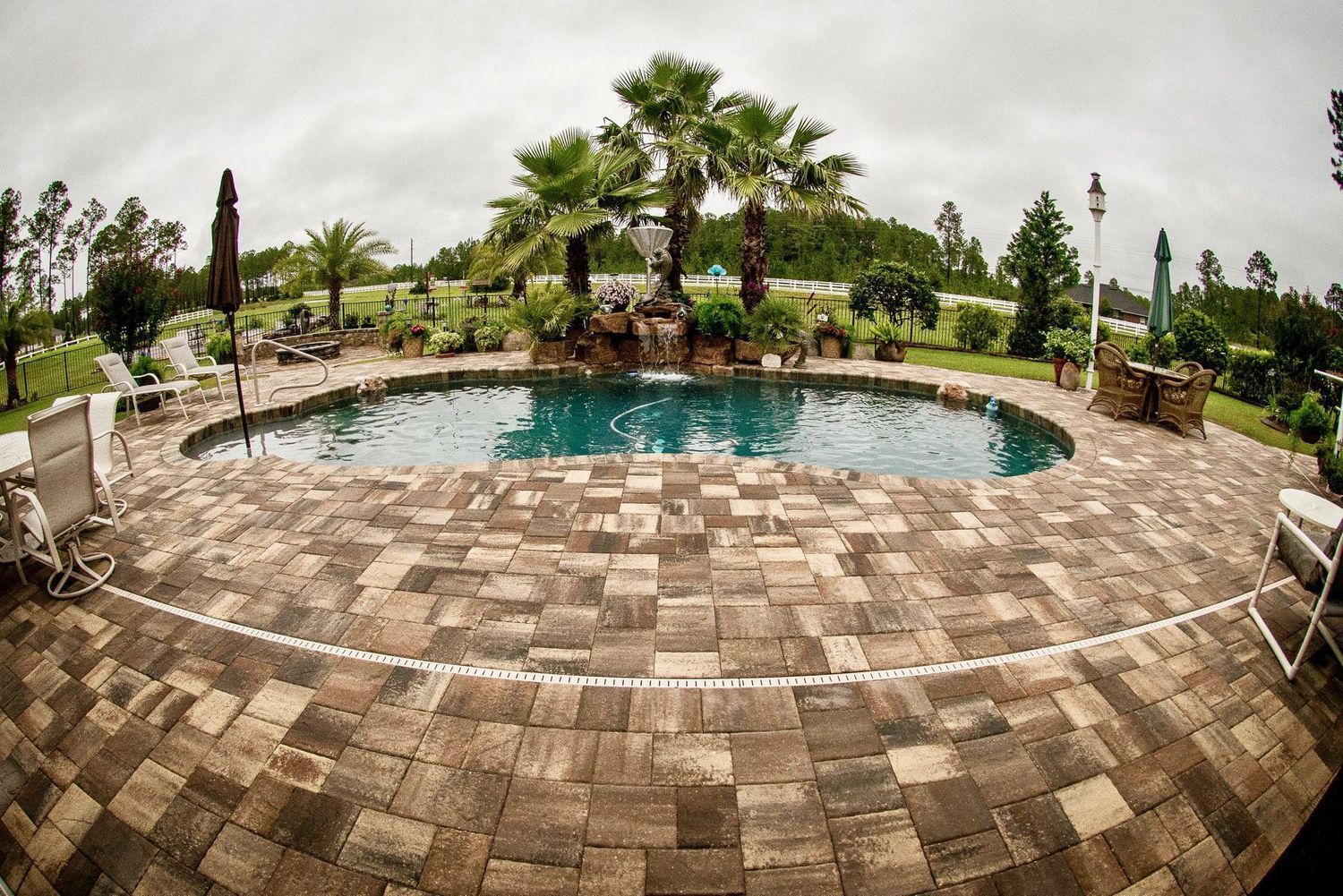 There is a large swimming pool in the middle of the patio.