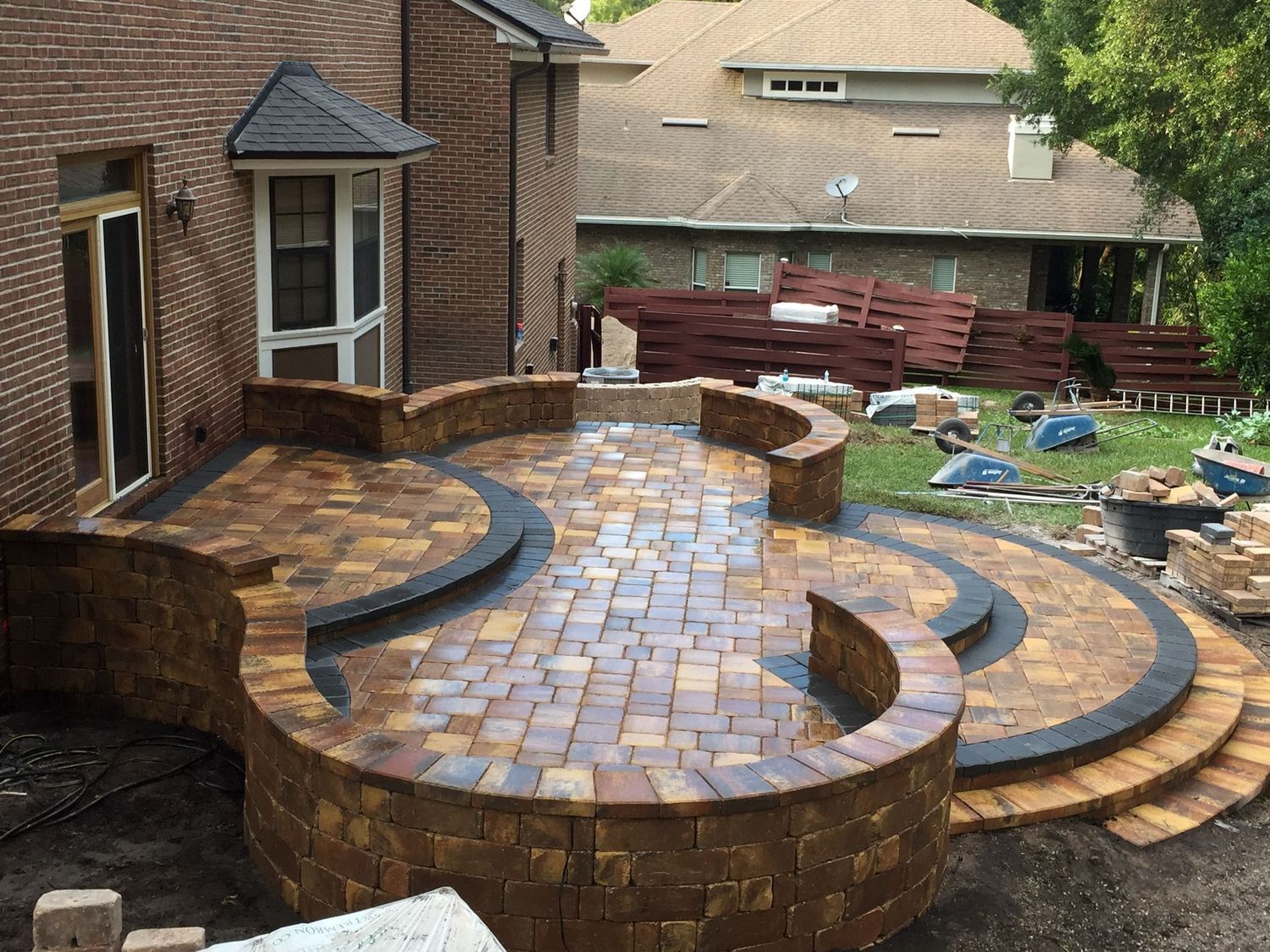 A brick patio is being built in front of a brick house.