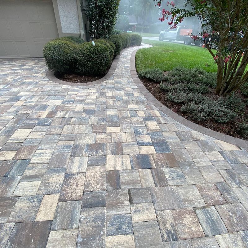 A brick driveway with a walkway leading to a garage.