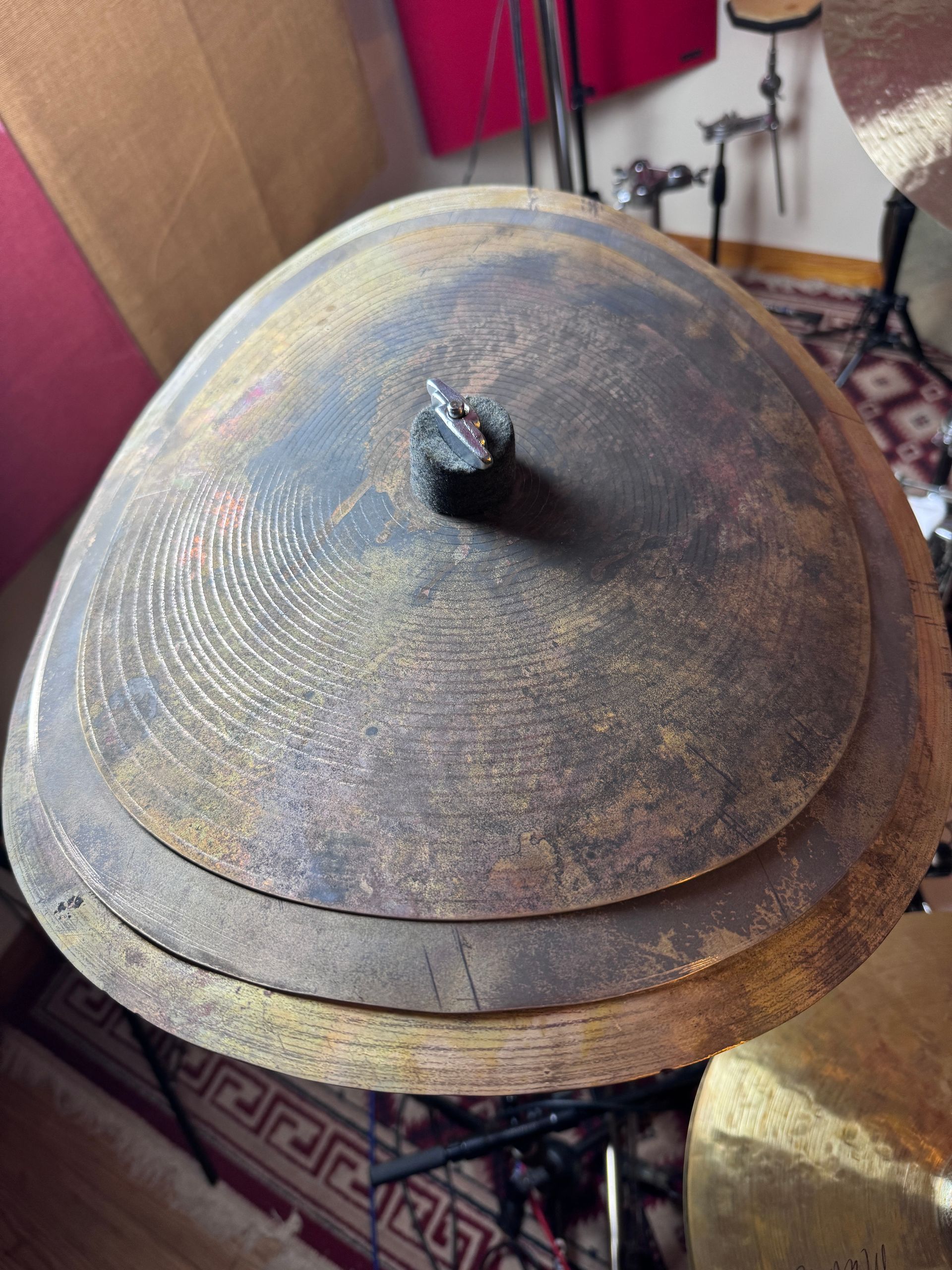 Stacked, circular drum cymbals in varying sizes, with a dark, textured appearance.