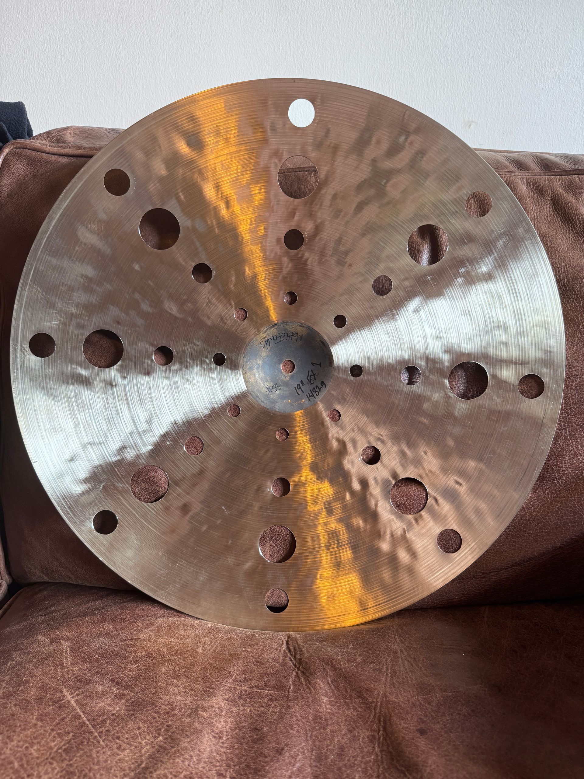 Bronze cymbal with several holes.