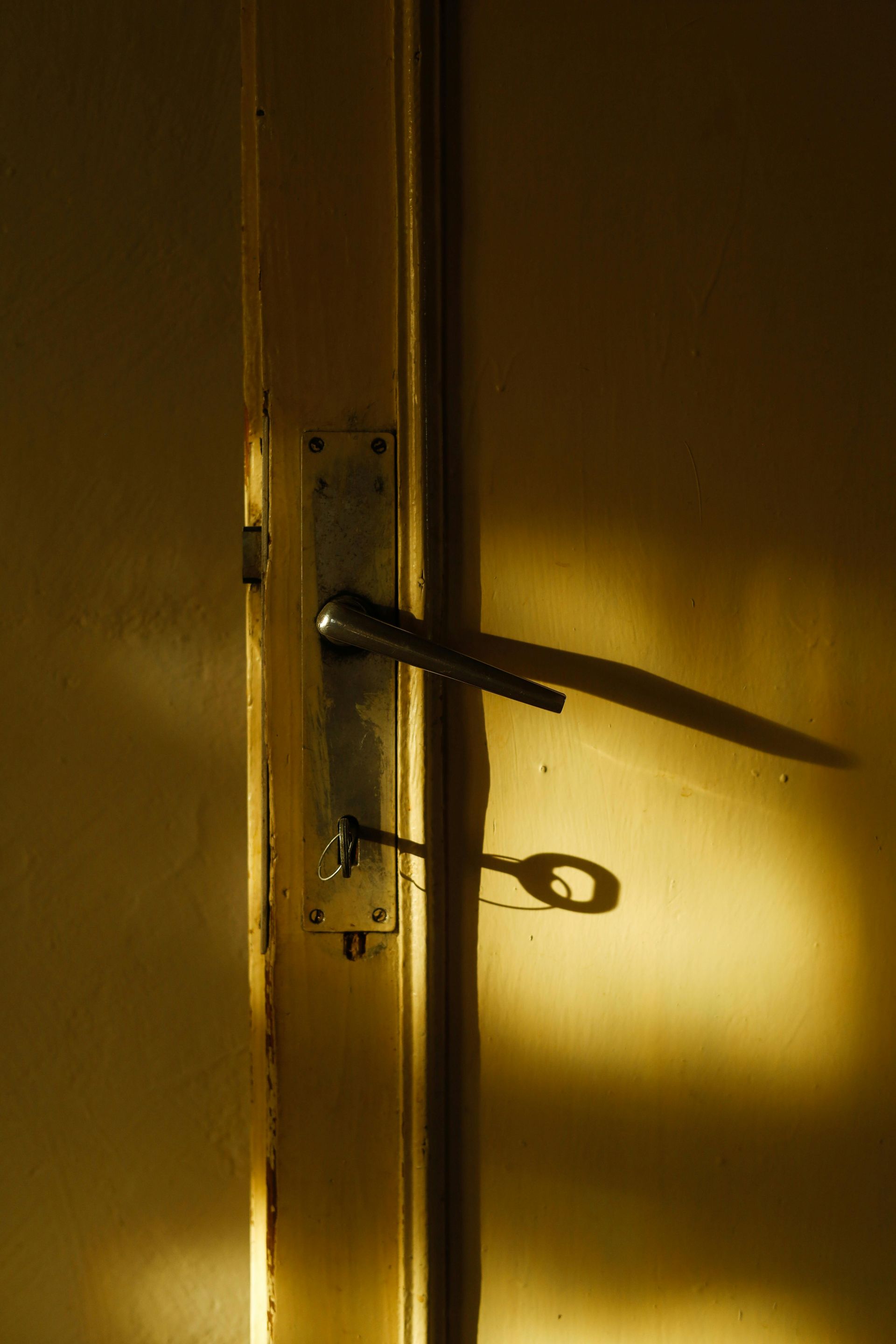 Door handle and key casting shadows in warm lighting.
