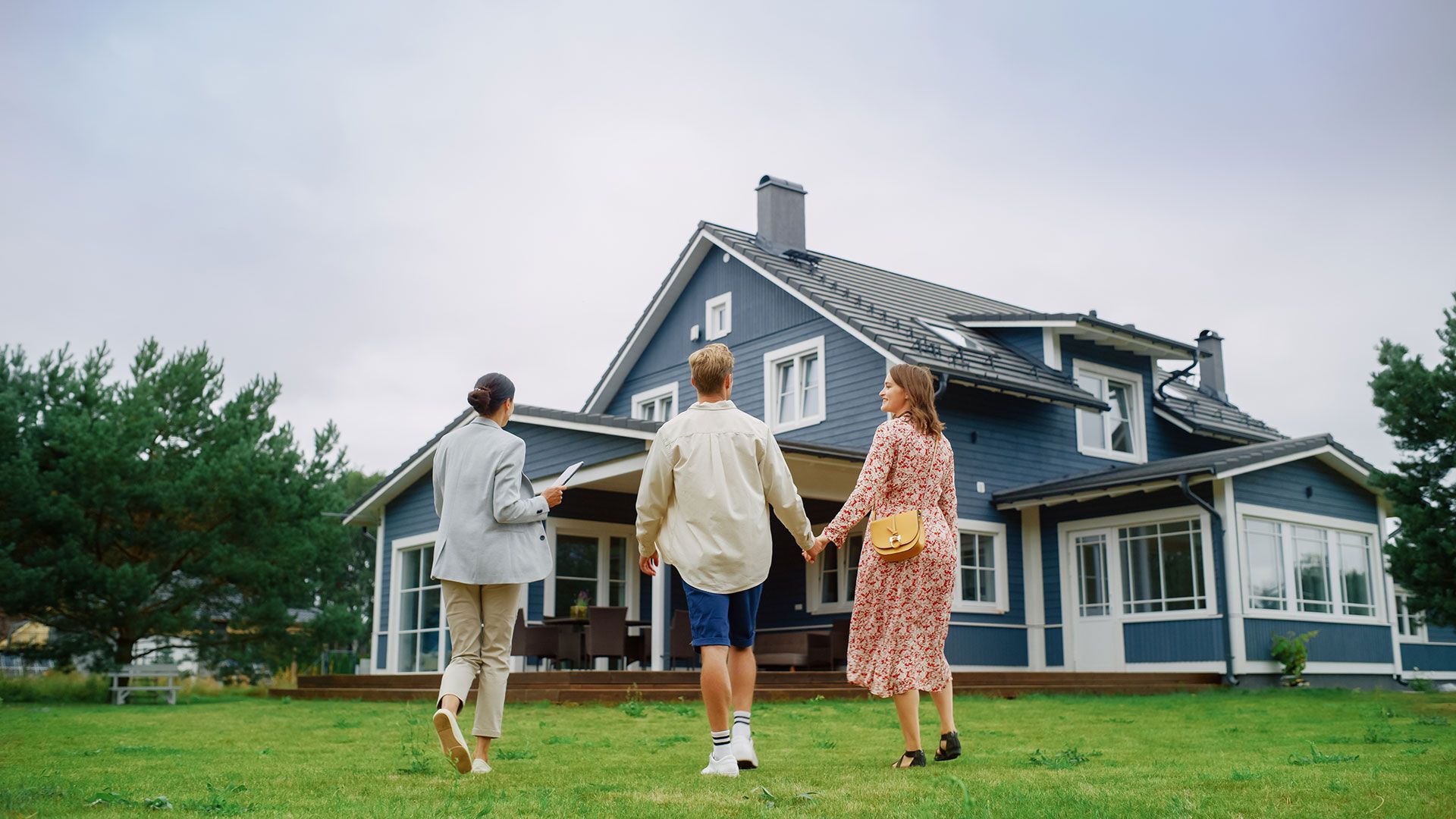 A group of people are walking towards a blue house.