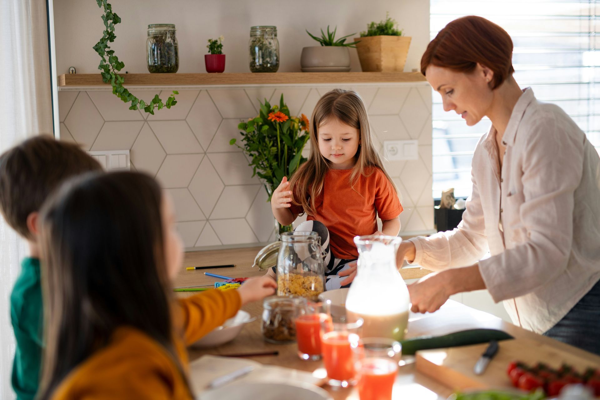 Woman and children preparing food in a kitchen.