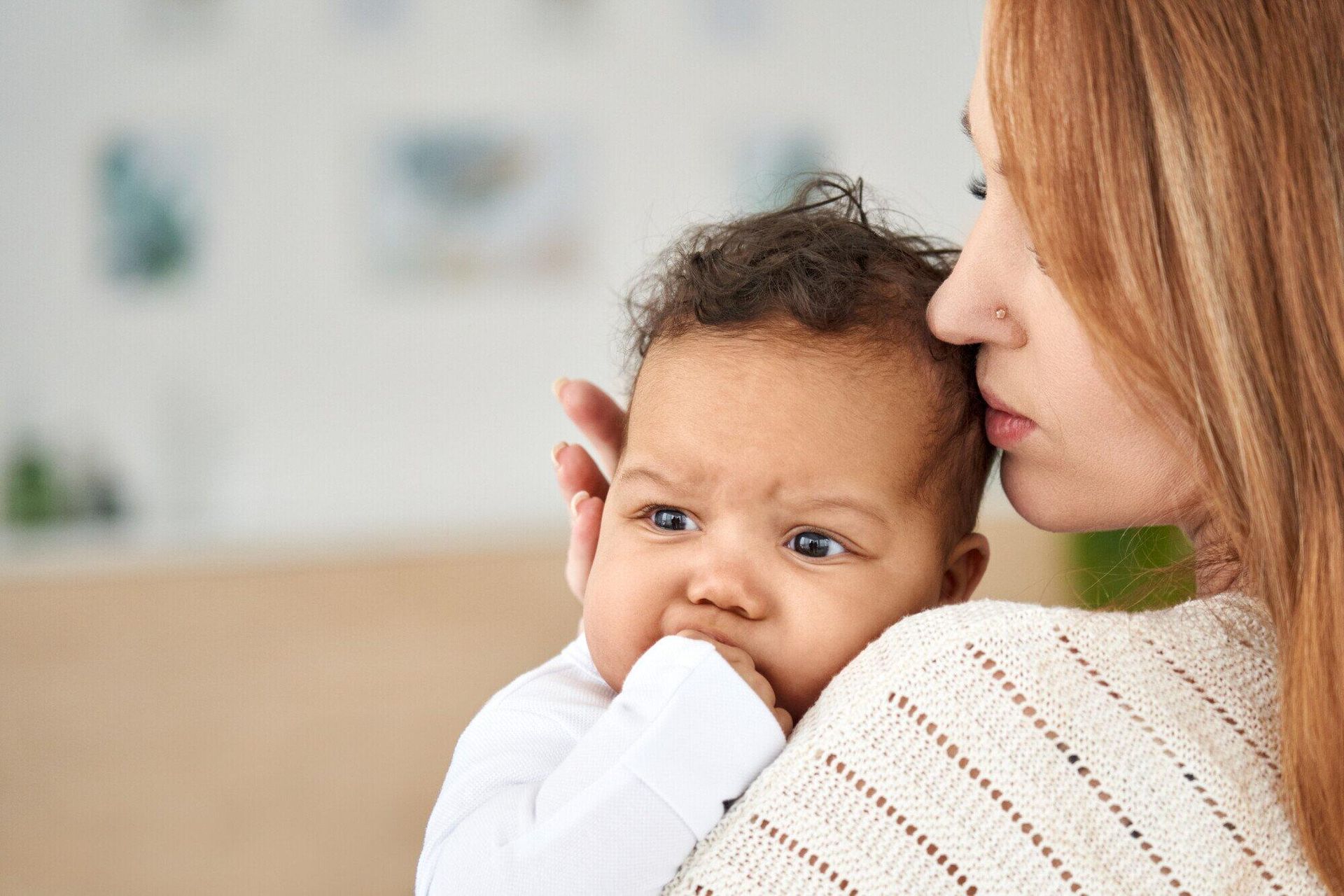 A woman is holding a baby in her arms.