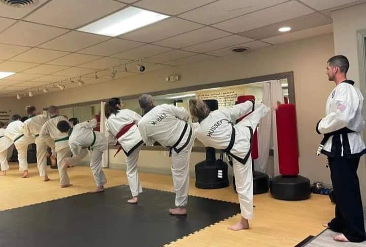 A group of people are practicing martial arts in a gym.
