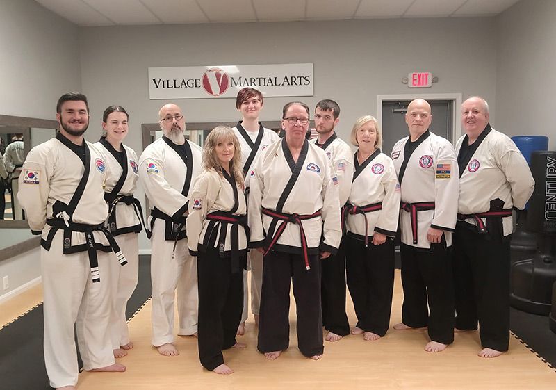 A group of people in martial arts uniforms are posing for a picture.
