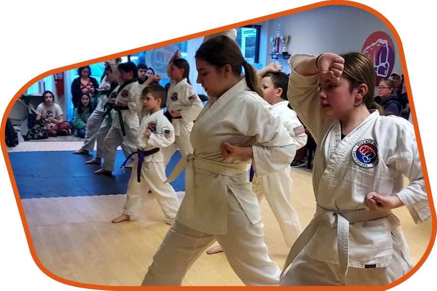 A group of children are practicing martial arts in a gym