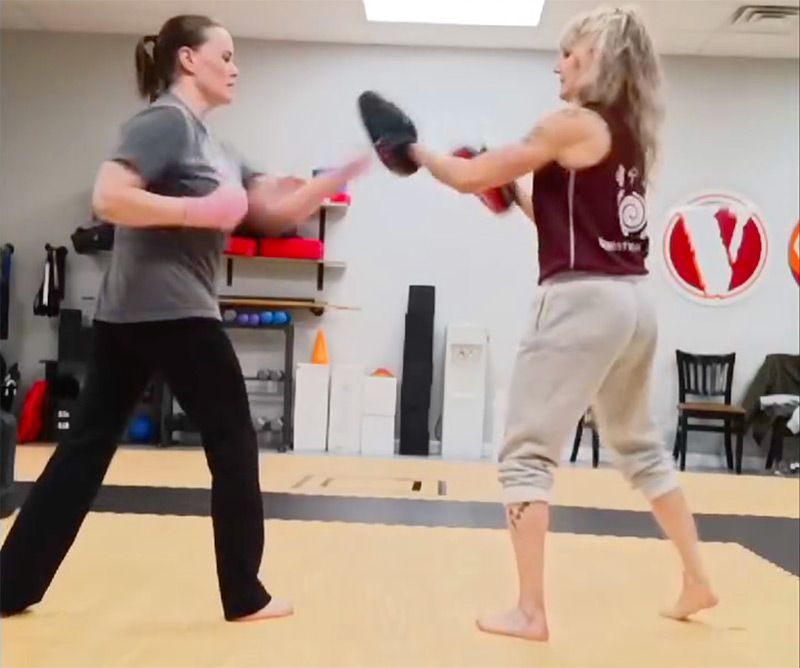 Two women are practicing martial arts in a gym