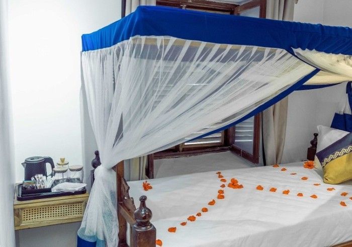 A bed with a blue and white canopy in a hotel room