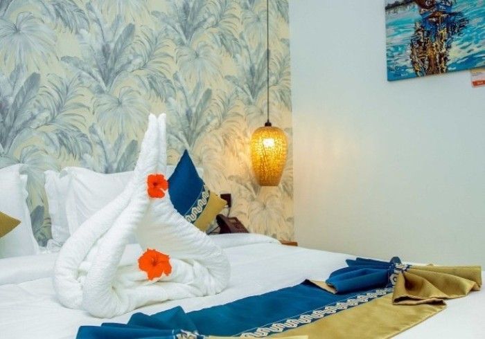 A bed with a swan made out of towels and flowers on it