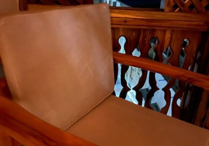 A white chair is sitting in front of a wooden railing