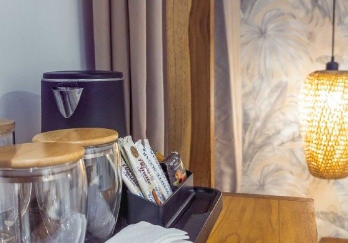 A hotel room with a wooden table and a lamp.