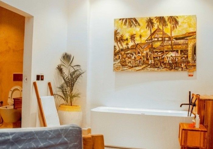 A bathroom with a bathtub and a painting on the wall.
