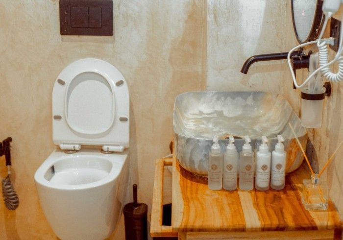 A bathroom with a toilet , sink and mirror.