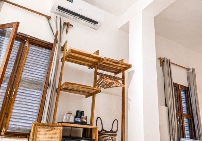 A room with a wooden shelf and a window