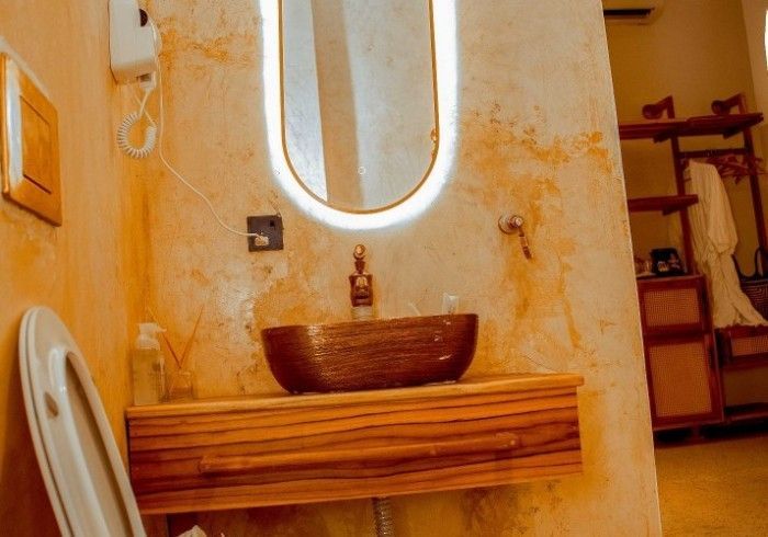 A bathroom with a sink , mirror and toilet.
