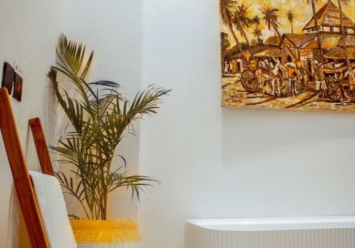 There is a painting on the wall above the bathtub in the bathroom.