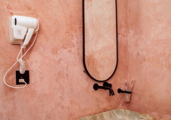 A bathroom with a hair dryer and a mirror on the wall.