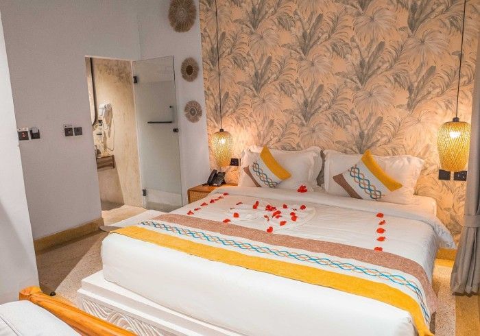 A hotel room with a king size bed and a bathroom.