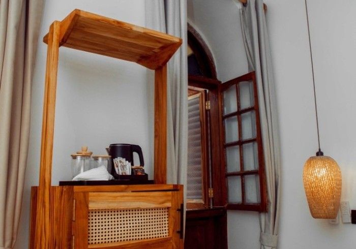 A hotel room with a wooden shelf and a window.