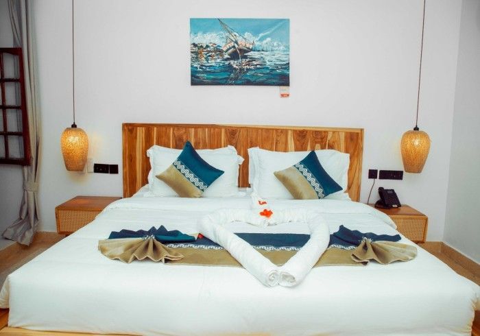 A hotel room with a large bed and a painting on the wall