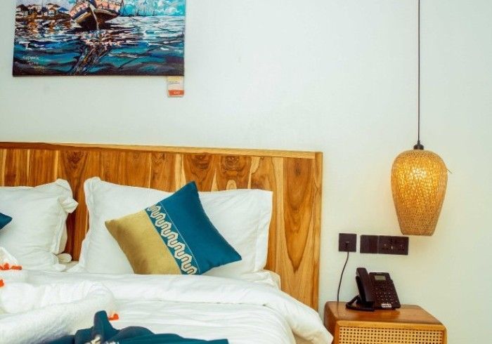There is a painting on the wall above the bed.
