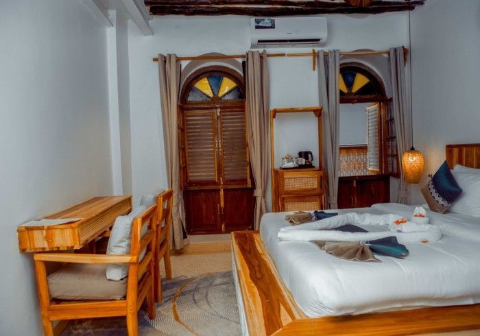 A hotel room with a bed , desk and chairs.